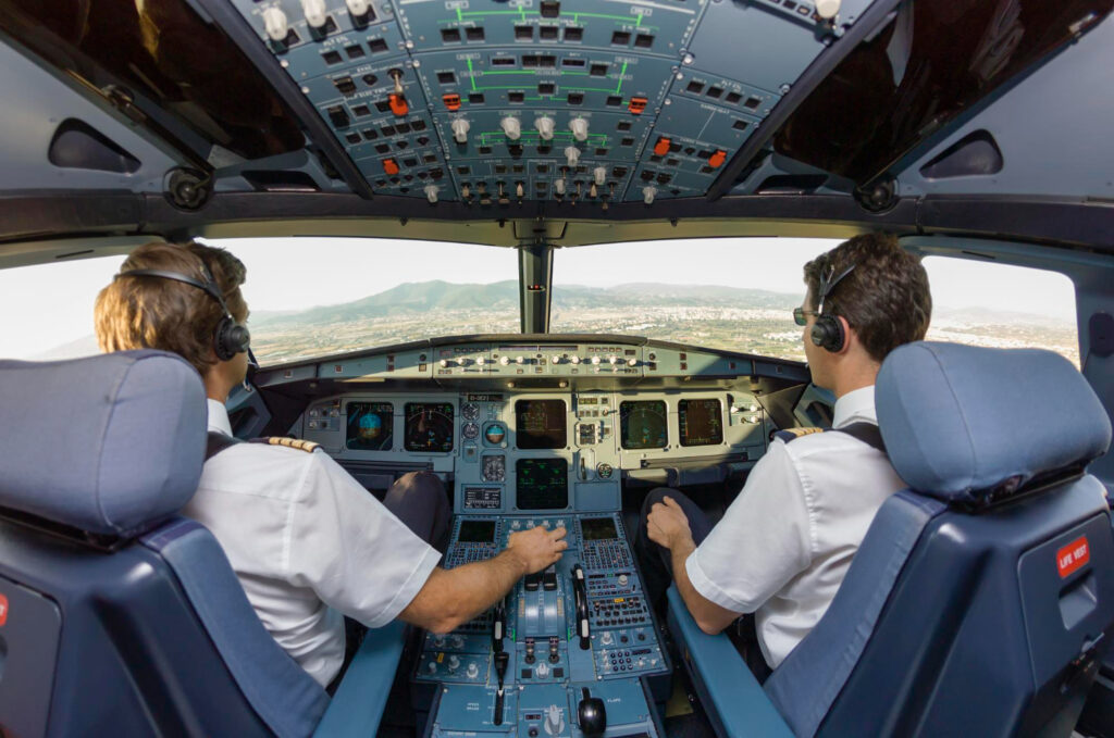 Pilot Gehalt: Kapitän und Copilot im Cockpit eines Verkehrsflugzeugs im Anflug